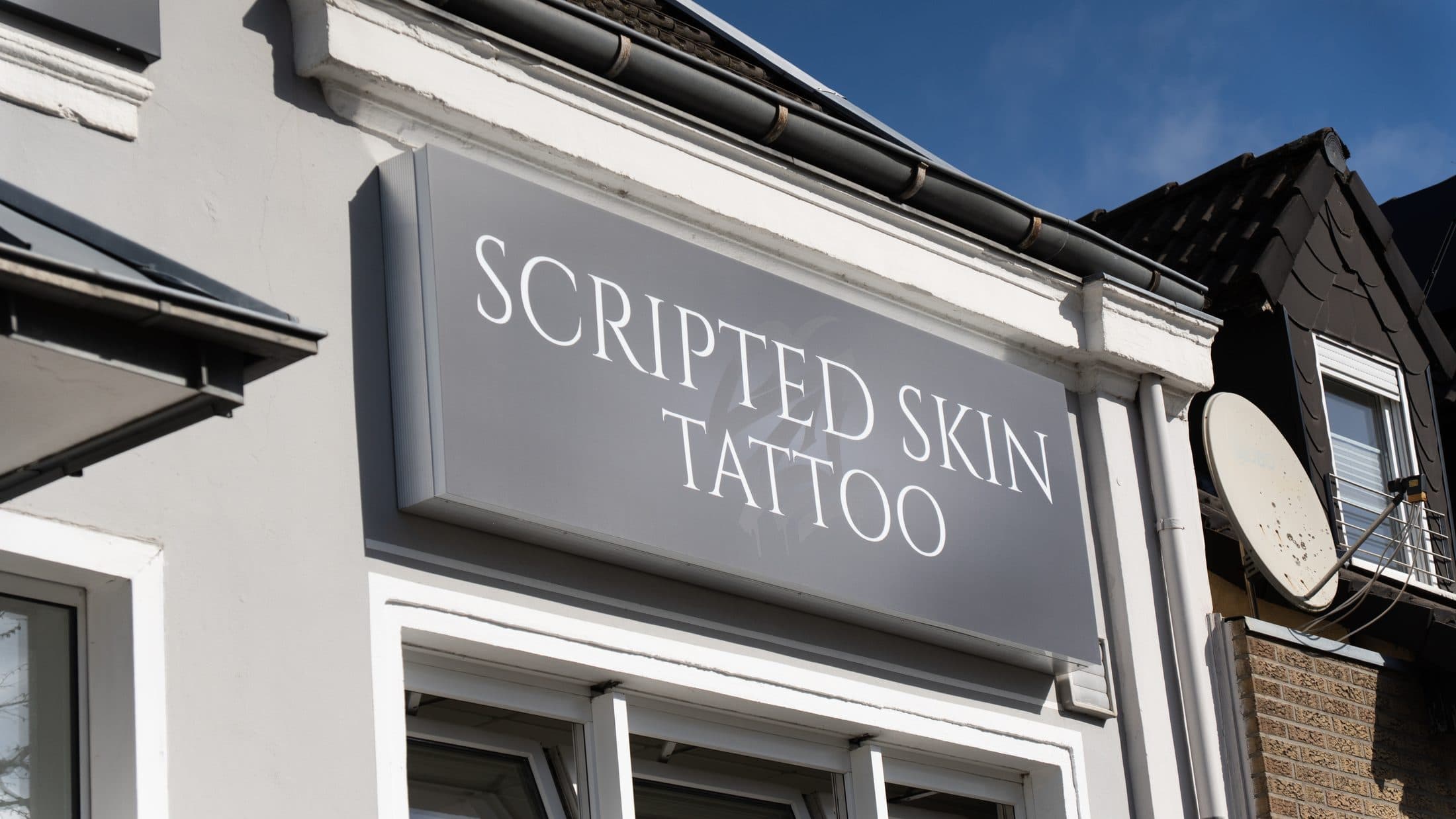 Schriftzug Scripted Skin Tattoo über dem Studioeingang